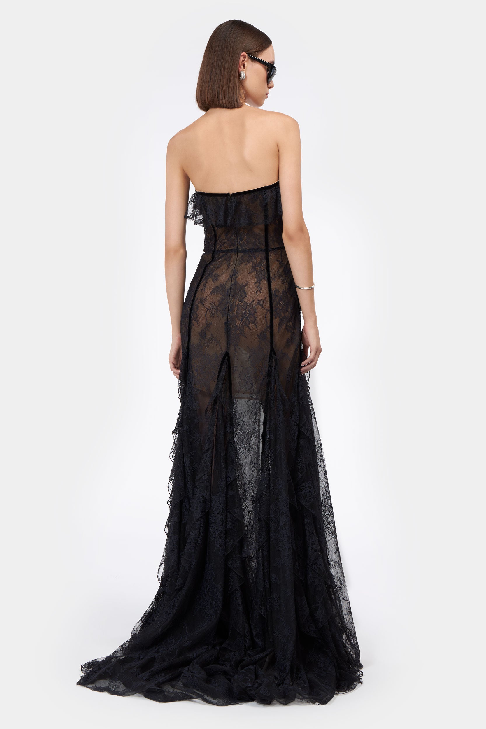 Back view of Rosaline Bustier Lace Gown featuring sheer lace fabric, strapless cut, and flowing train for a dramatic and elegant finish.
