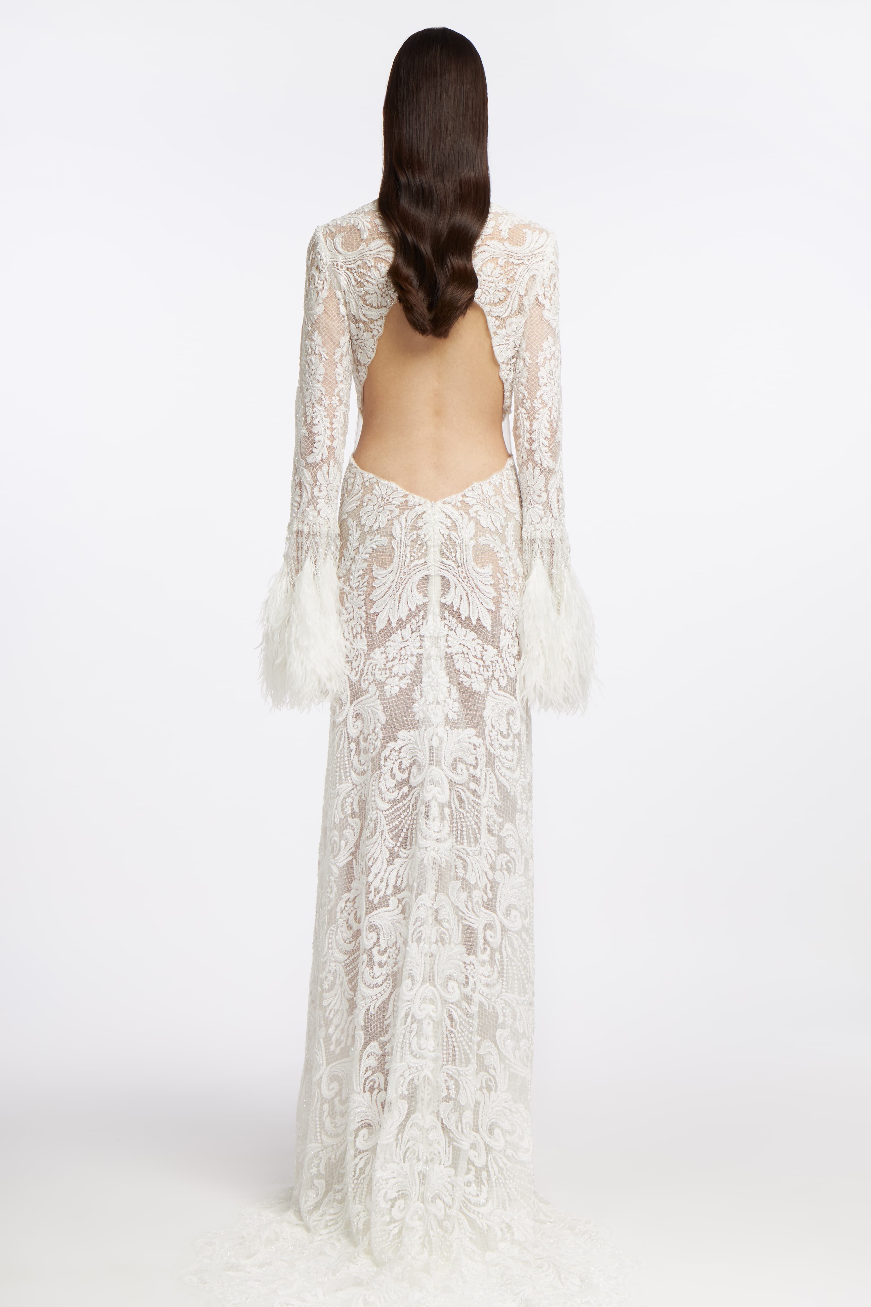 Back view of the Panorea Beaded Lace Gown highlighting an open-back design, intricate lace detailing, and a flowing train for a sophisticated bridal look.