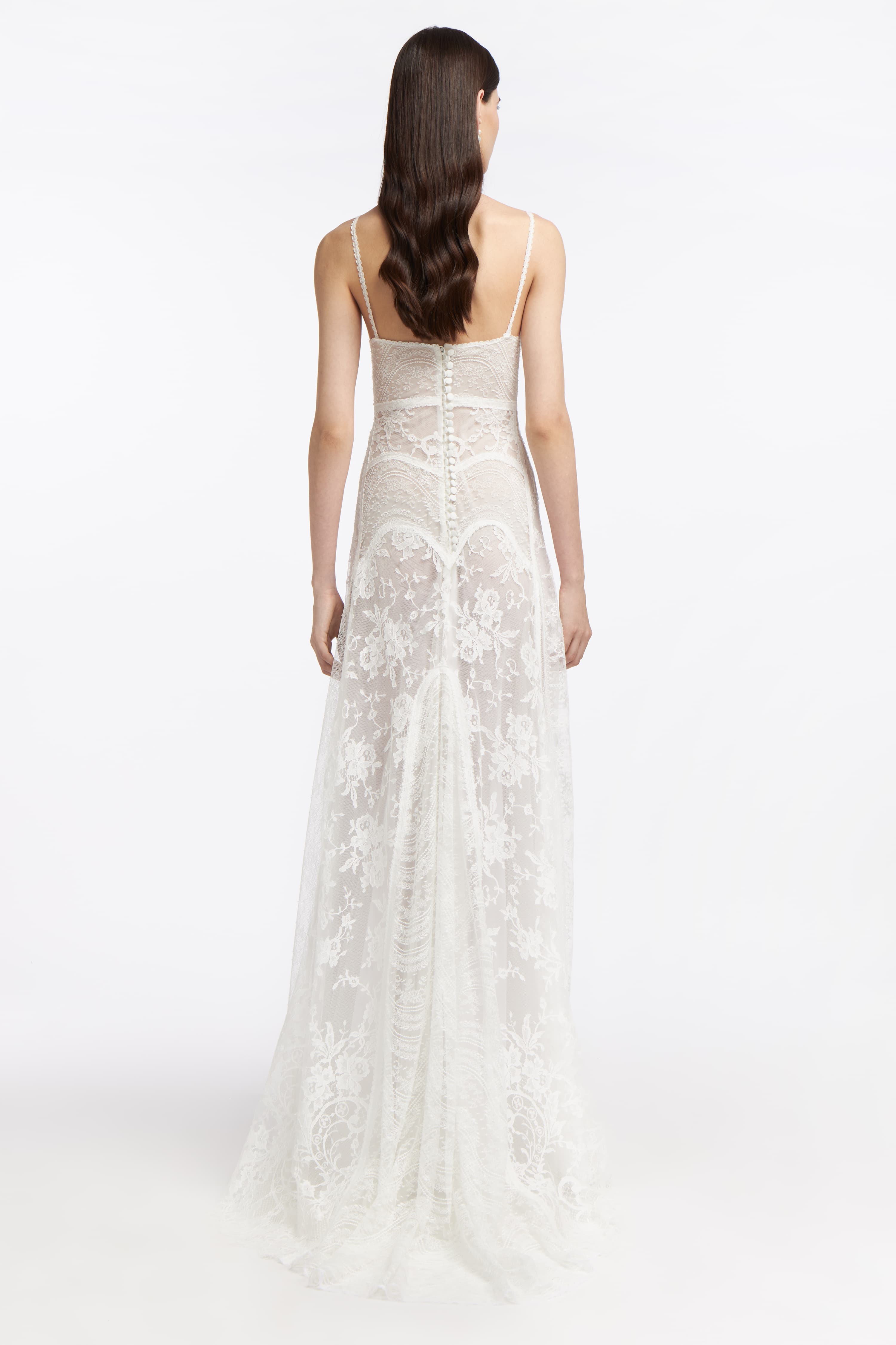 Back view of the Ourania French Lace Gown with sheer lace panels and a button-down closure. A timeless choice for wedding elegance.