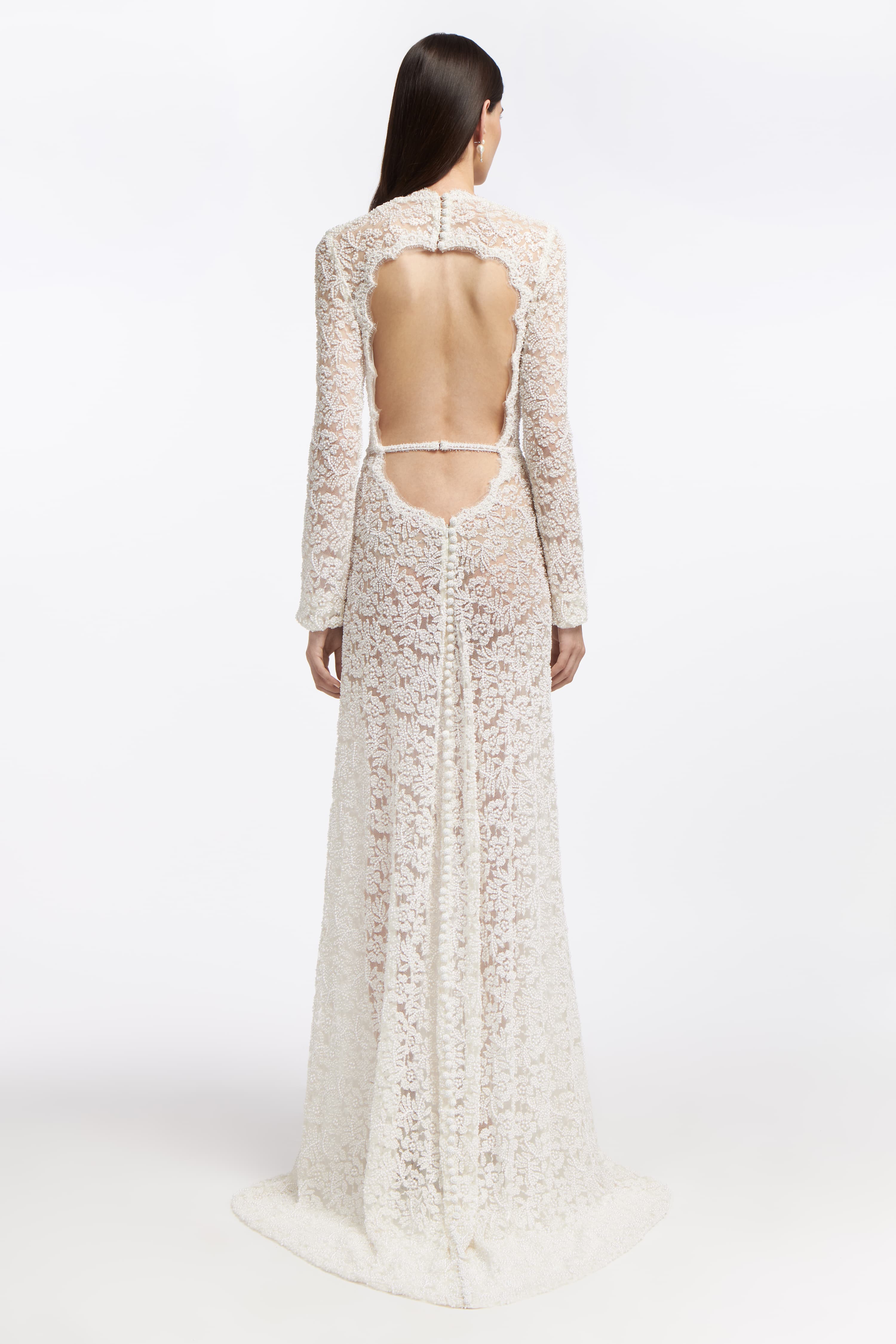 Back view of the Rhodea Beaded Open-Back Gown with a dramatic open-back design and button detailing. A stunning wedding dress for modern brides.
