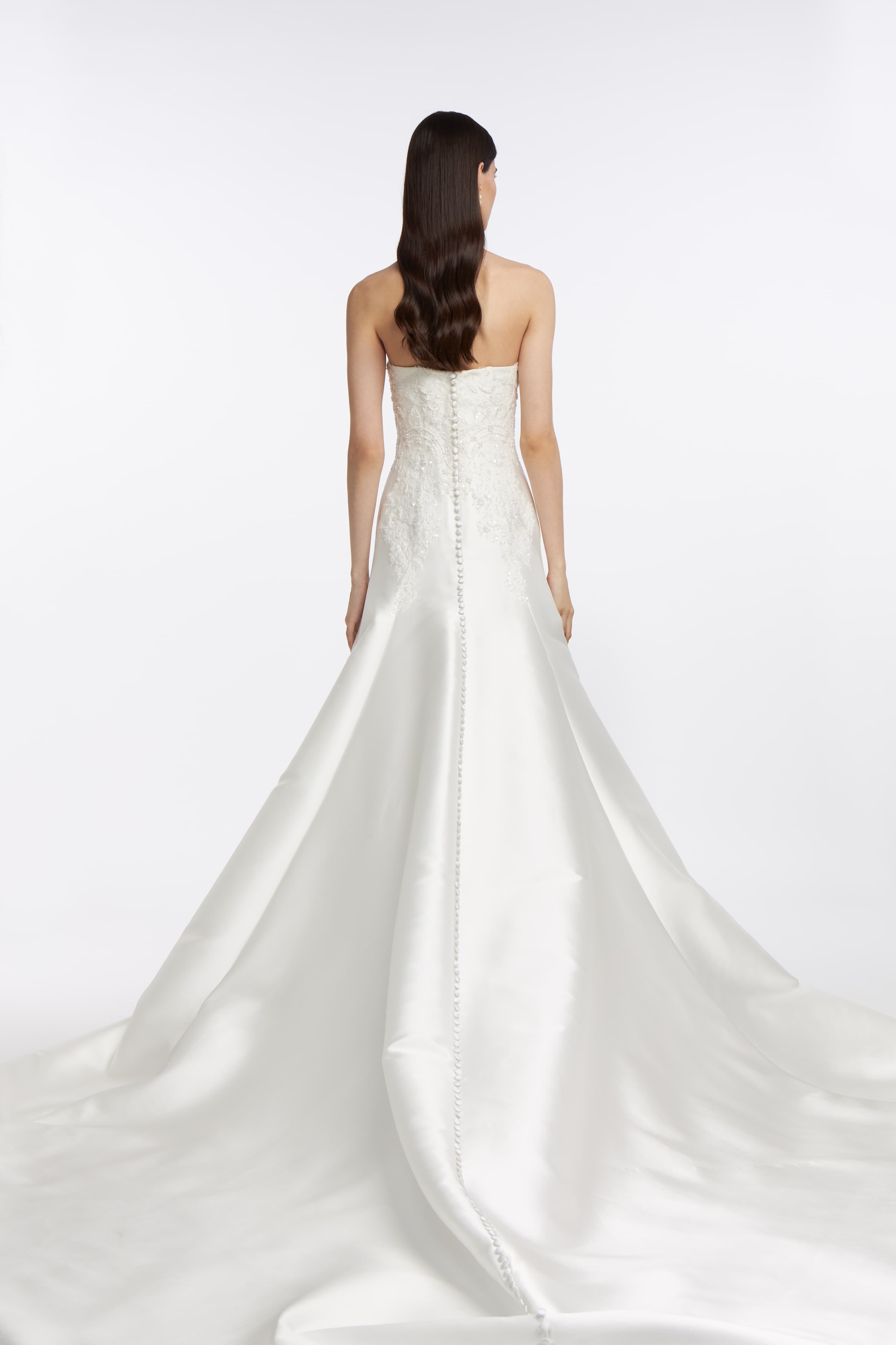 Back view of the Eris Mikado Bustier Gown highlighting a row of covered buttons and a dramatic train in luxurious mikado fabric.