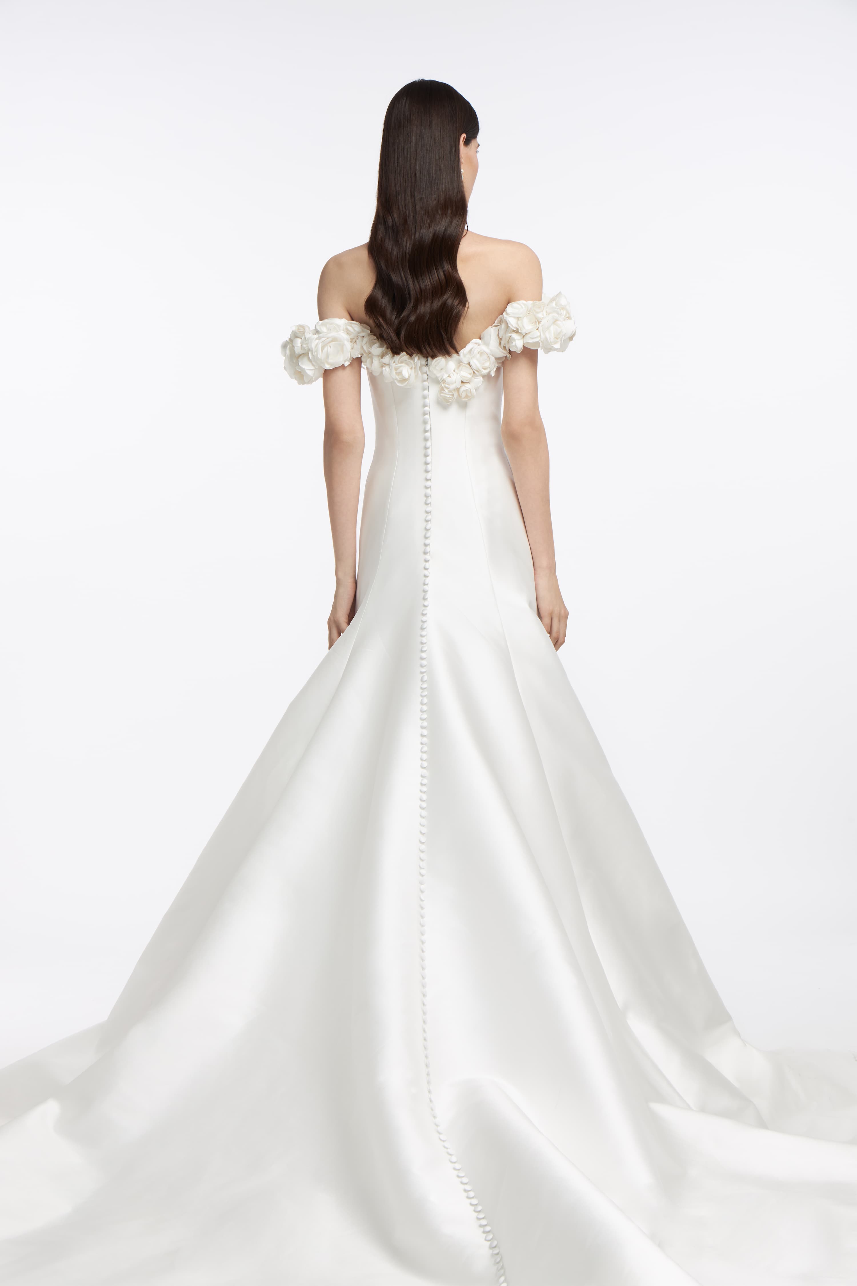 Back view of the Harmonia Mikado Off-Shoulder Gown with a dramatic train and button detailing. A timeless wedding dress for a sophisticated bridal look.