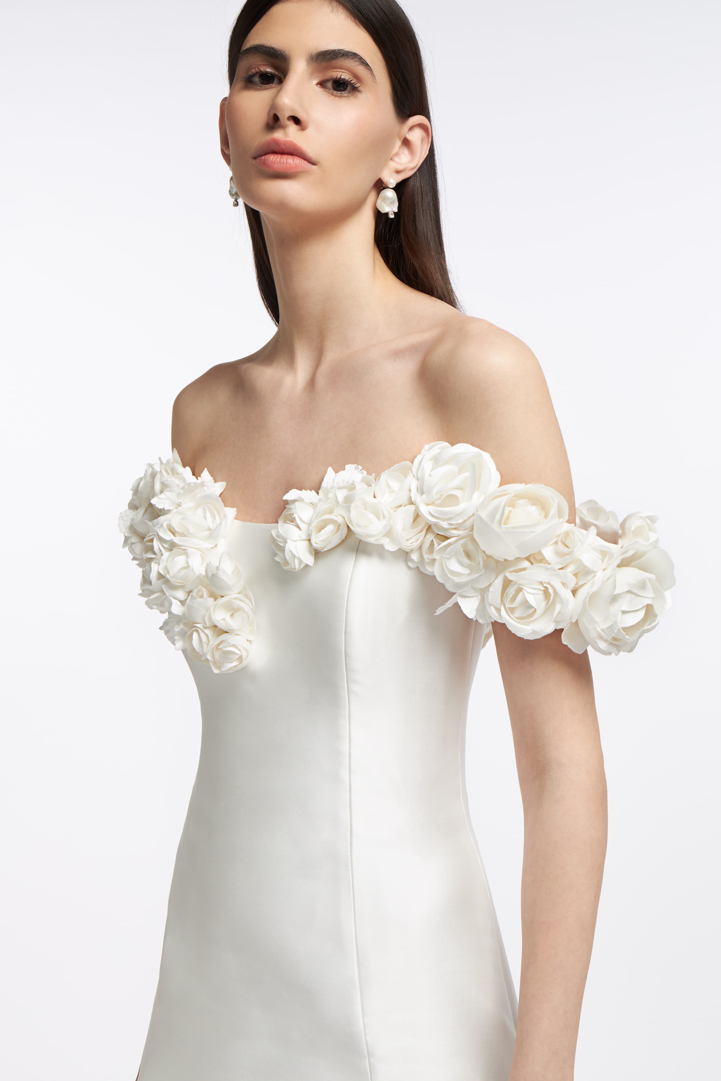 Close-up of the Harmonia Mikado Off-Shoulder Gown showcasing delicate floral appliqué on the sleeves and a structured bodice. Elegant choice for modern brides.