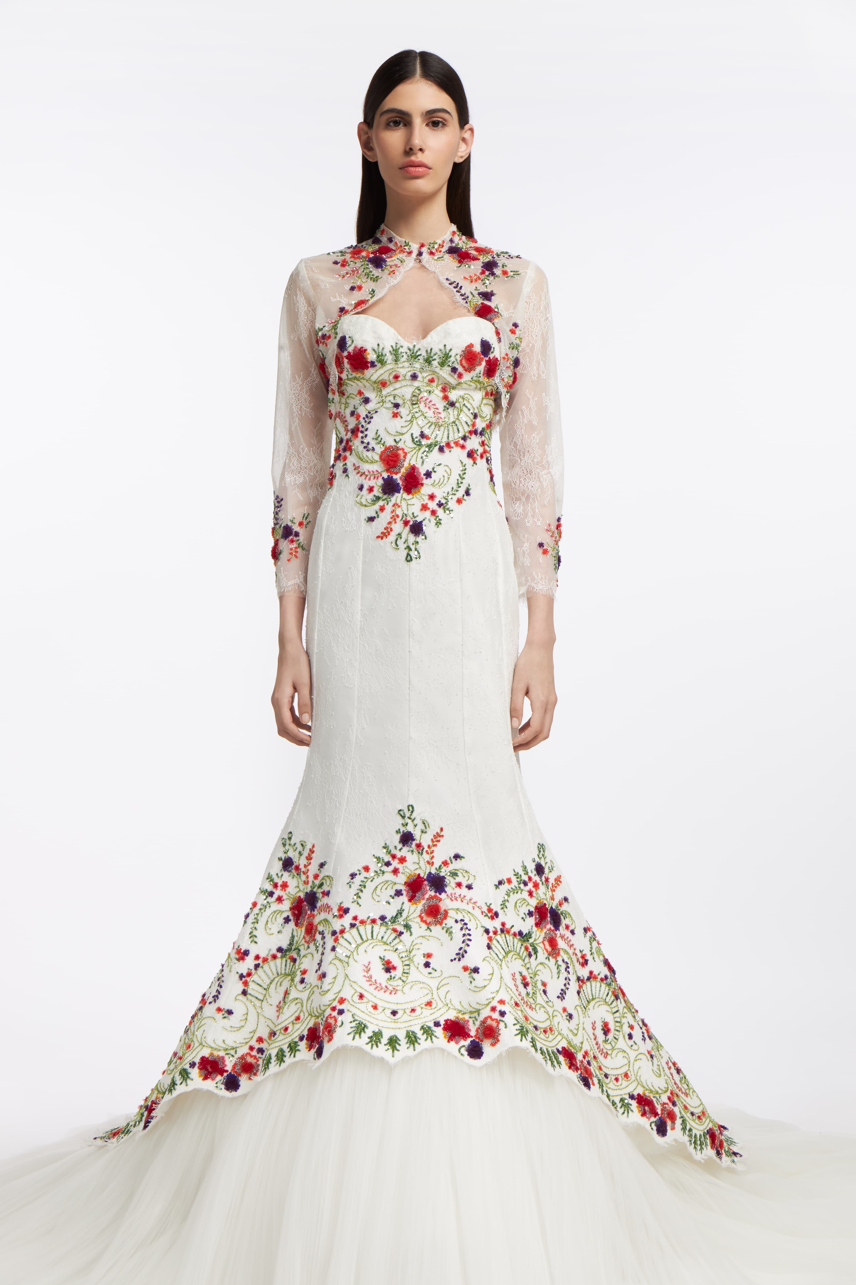 Melinoë Chantilly Lace Gown styled with a sheer lace bolero, featuring embroidered floral details and long sleeves for an elegant bridal look.