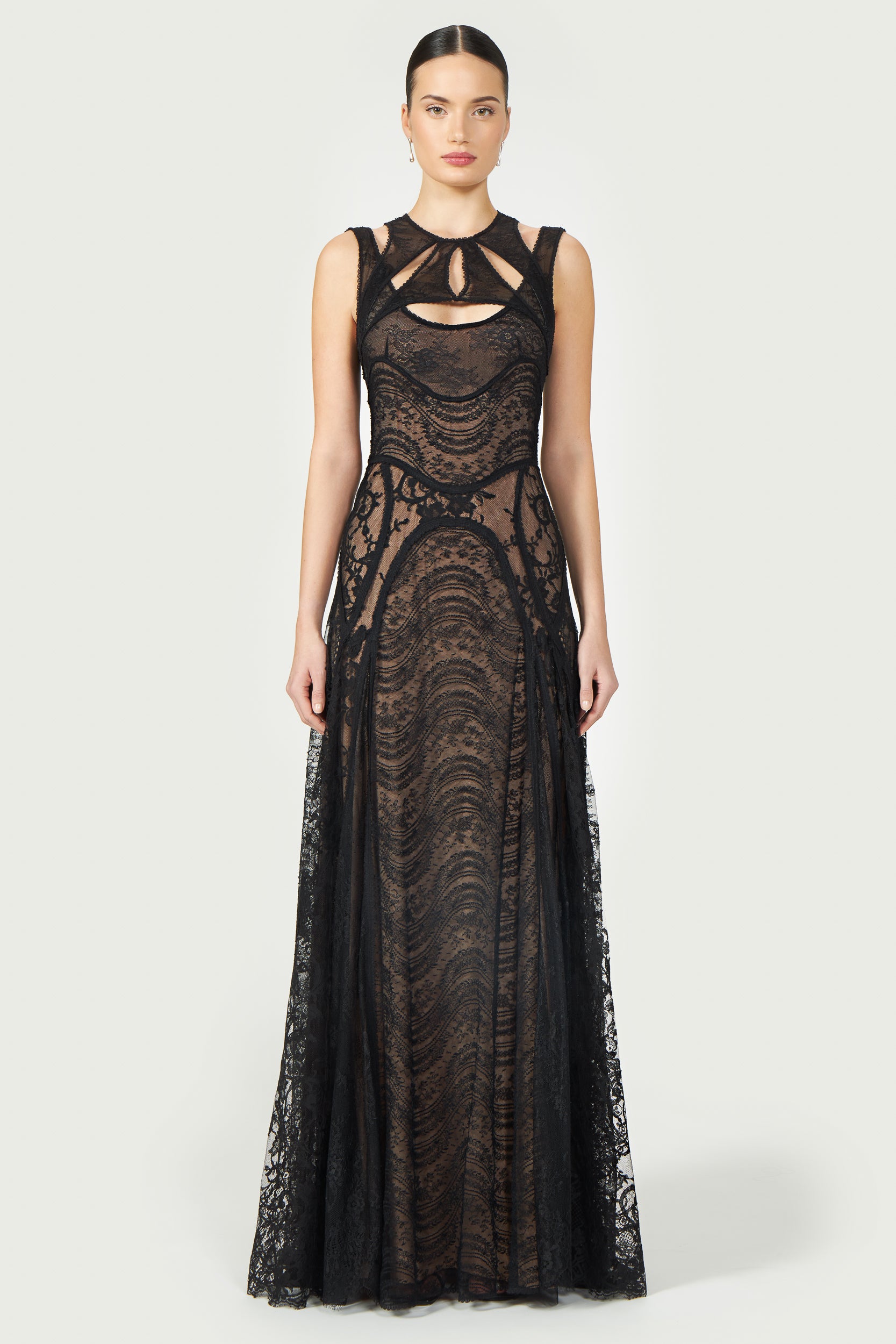 Massima Patchwork Lace Gown in black with intricate lace detailing, sleeveless design, and cutout accents. A floor-length elegant dress for special occasions.