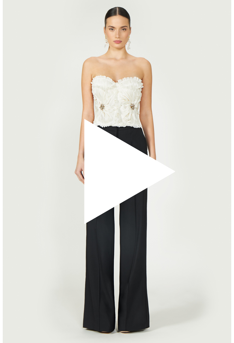 Video preview of Ezra Lurex Georgette Bustier styled with black trousers. Off-white strapless top with floral pleats and jeweled accents for Resort 2025.