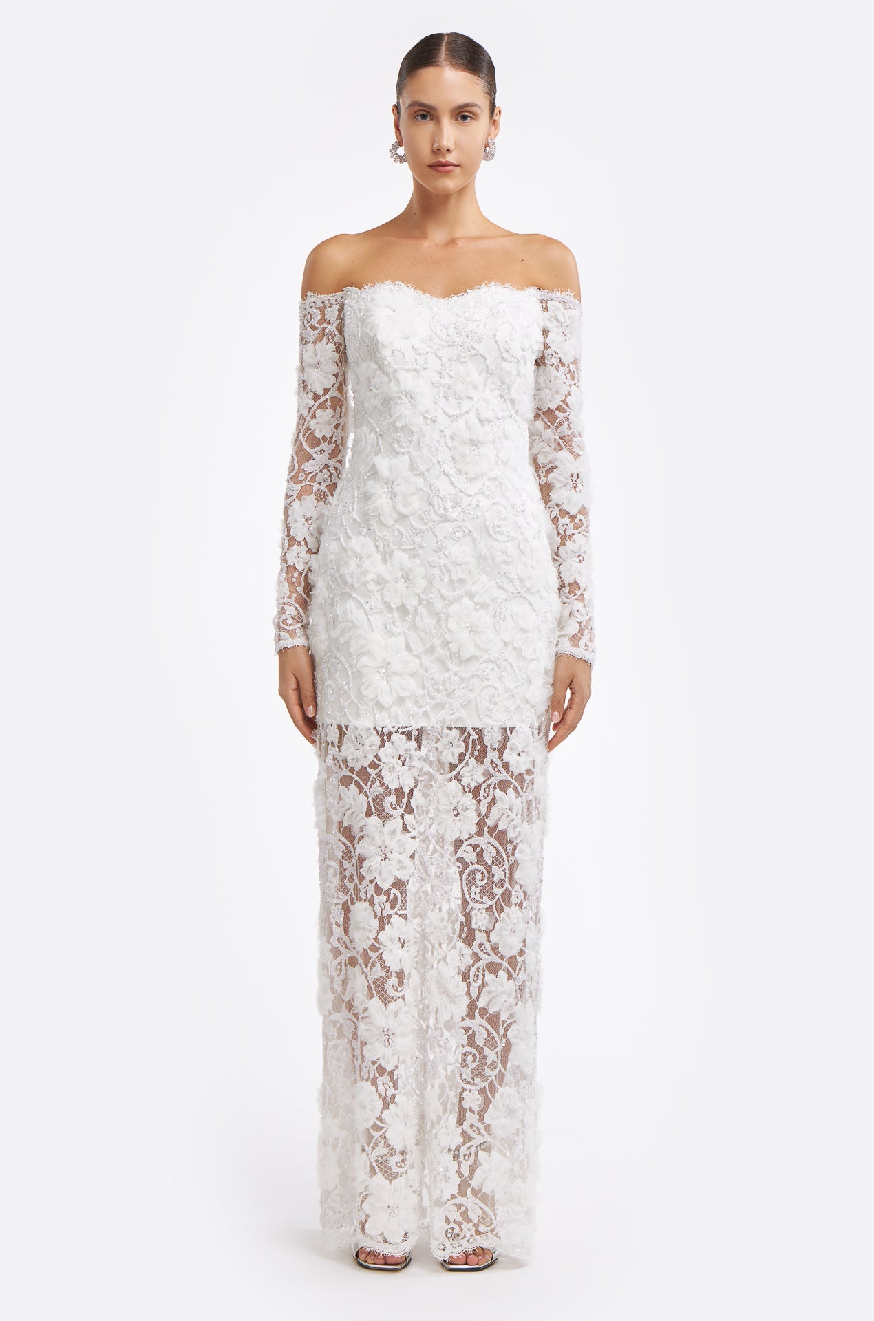 Chrisanthi Embellished Lace Gown featuring an off-the-shoulder neckline, long lace sleeves, and a sheer floral lace overlay. Elegant bridal dress for Fall 2025.