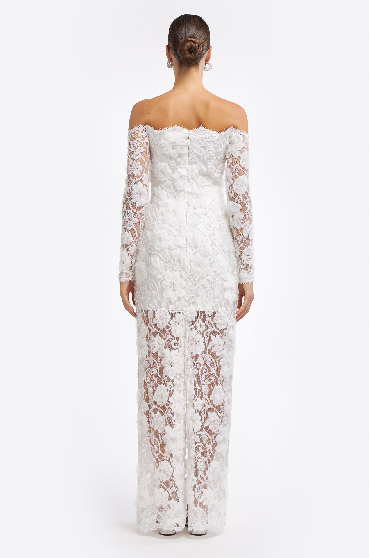Back view of the Chrisanthi Embellished Lace Gown with a sheer lace skirt, off-the-shoulder neckline, and delicate floral embellishments. A stunning wedding dress for Fall 2025.