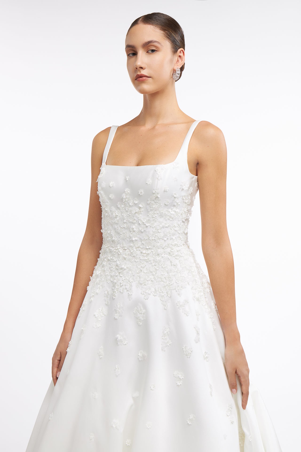Close-up of Clelia Mikado Gown showcasing intricate floral appliqué on the bodice. A sophisticated wedding dress with delicate detailing for modern brides.