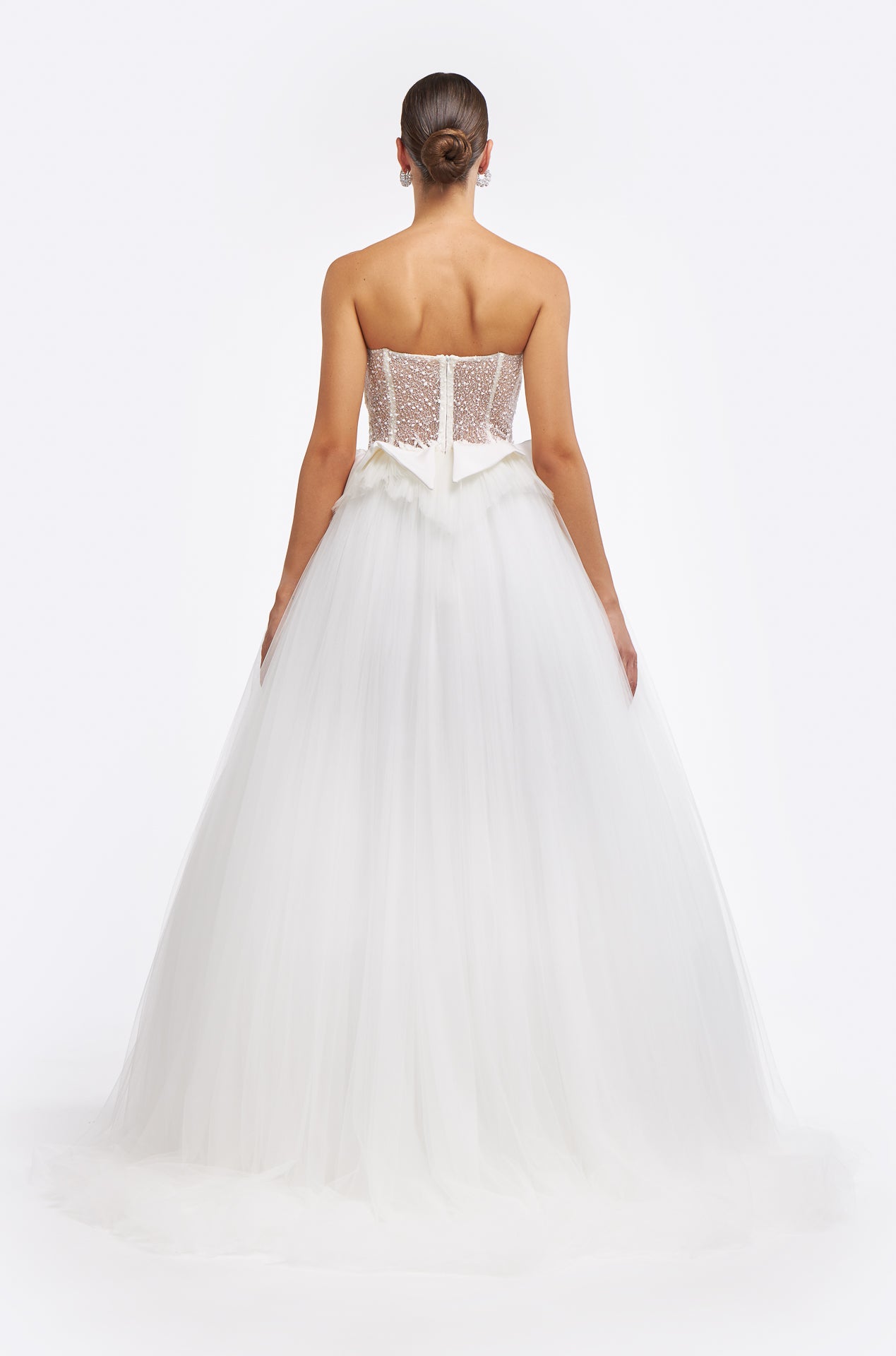 Back view of the Emmelia French Tulle Gown showcasing a sheer corset bodice, delicate lace details, and a flowing tulle skirt. Perfect for a bridal statement.