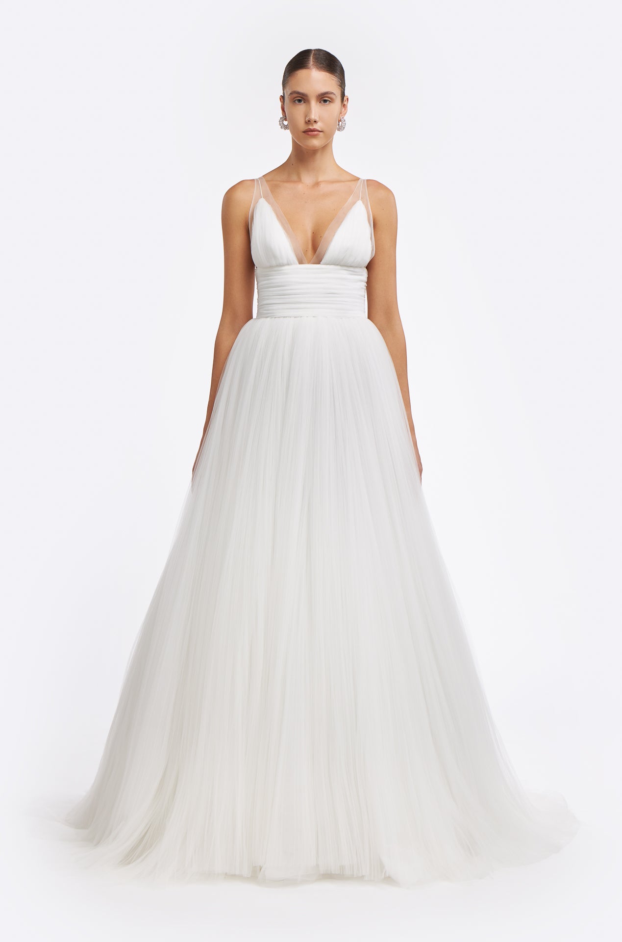 Melantha Plissé French Tulle Gown featuring a deep V-neckline, delicate sheer straps, and a voluminous tulle skirt. Perfect for a bridal look in Fall 2025.