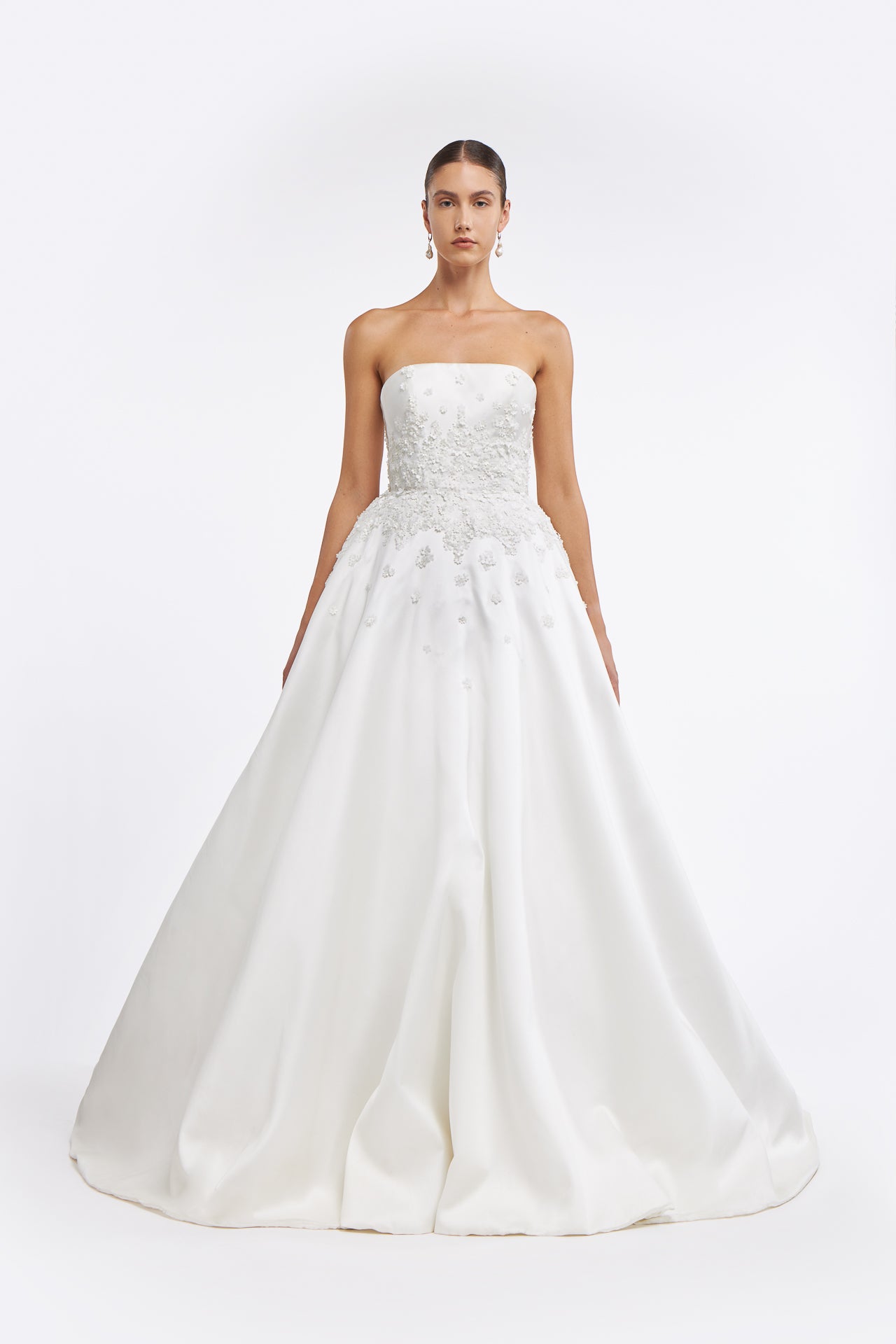 Vasia Mikado Strapless Gown featuring a structured bodice with floral appliqués and a voluminous A-line skirt. Elegant bridal design for Spring 2025.