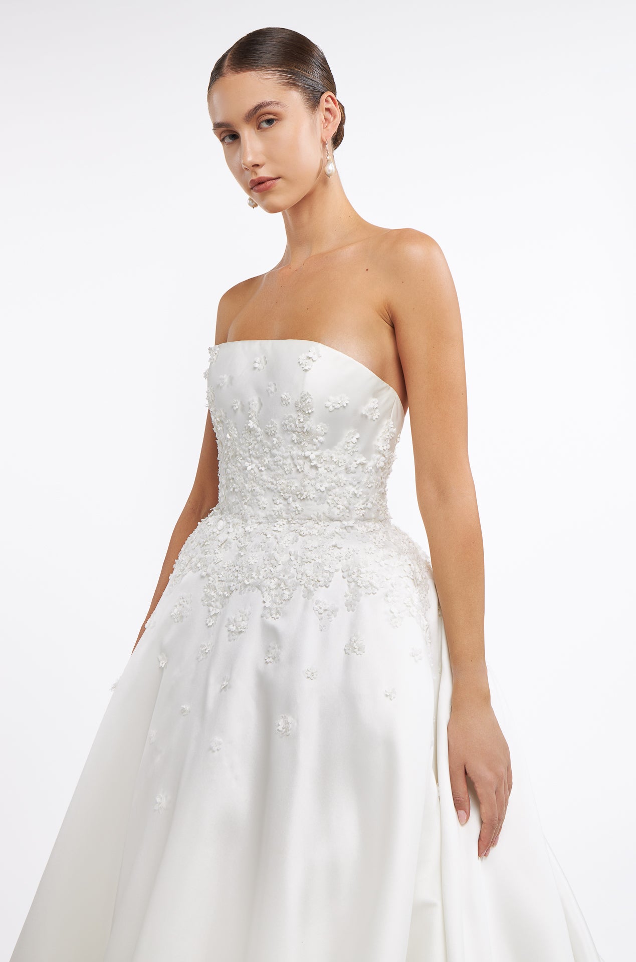 Side view of Vasia Mikado Strapless Gown showcasing intricate floral embellishments on the bodice. A timeless wedding dress for modern brides.