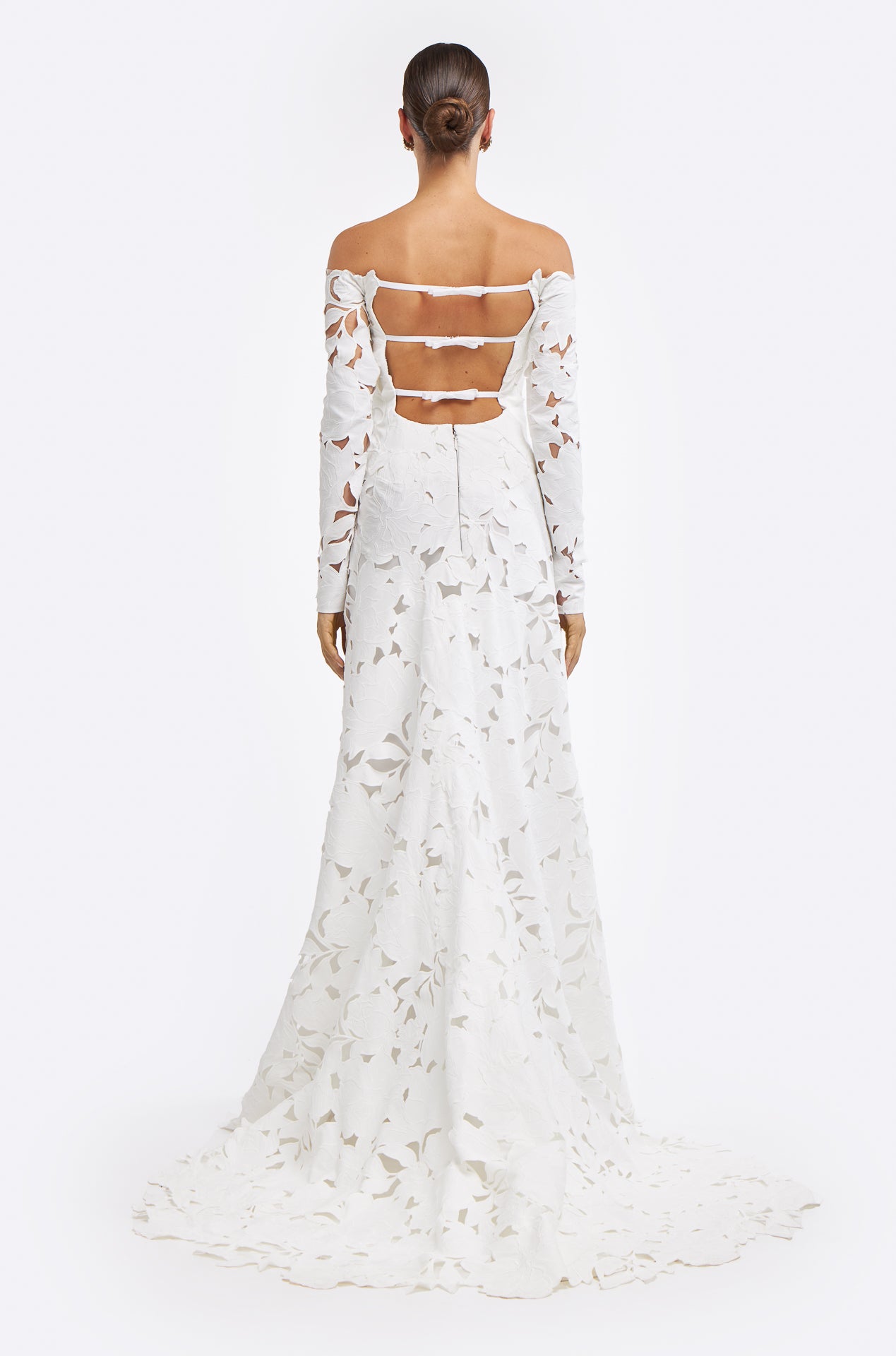 Back view of the Oriane Floral-Cut Lace Gown highlighting its open-back design with multiple straps and a flowing train. The floral lace cutouts add a modern bridal touch.