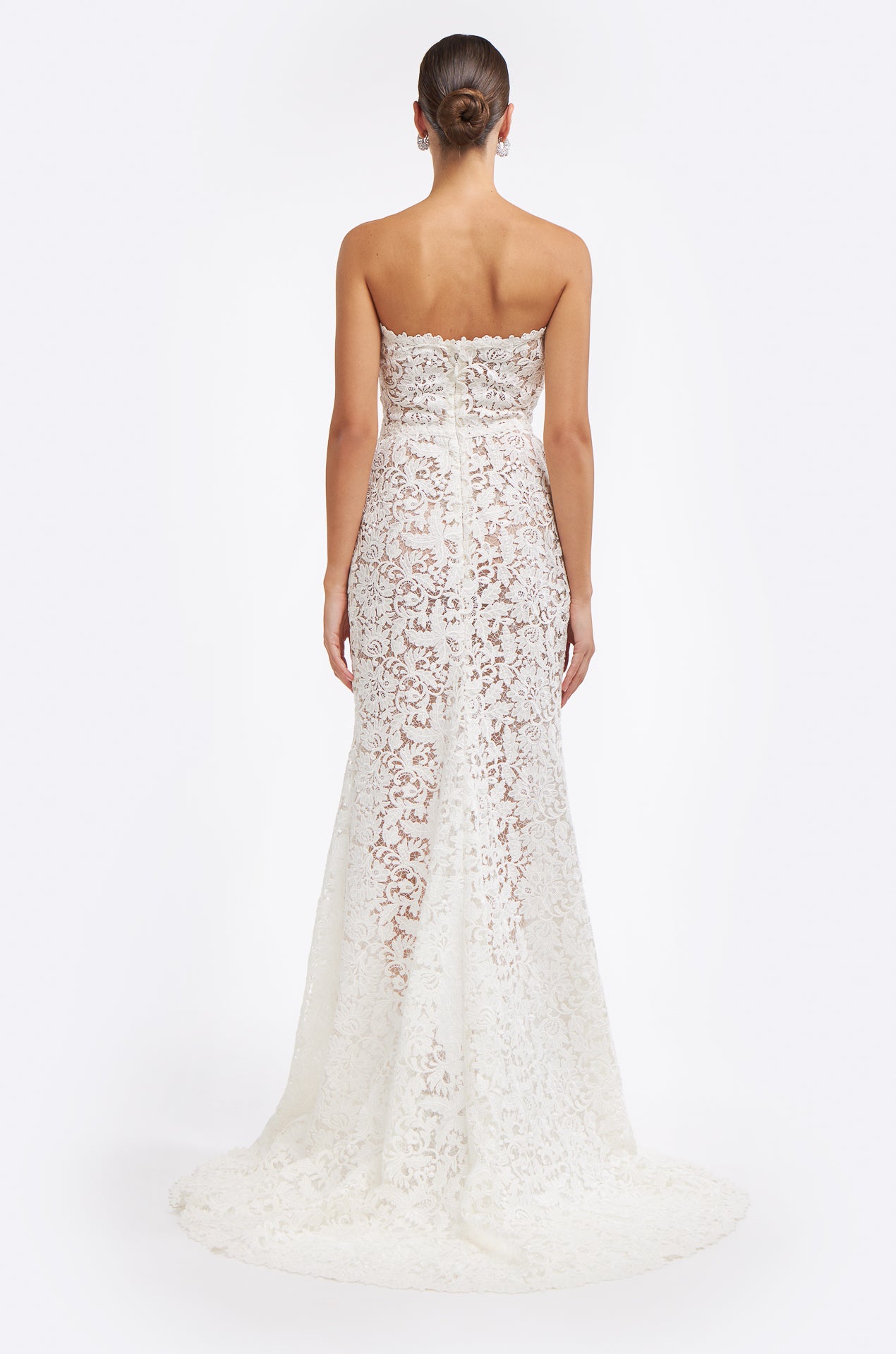 Back view of the Valeria Corded Lace Strapless Gown showcasing delicate lace patterns, a button-up closure, and a graceful train.