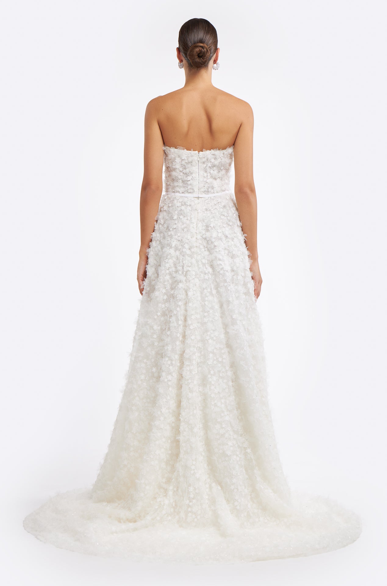 Back view of the Fereniki Embroidered Lace Gown showcasing a strapless design, floral appliqué, and a flowing train for an elegant bridal silhouette.
