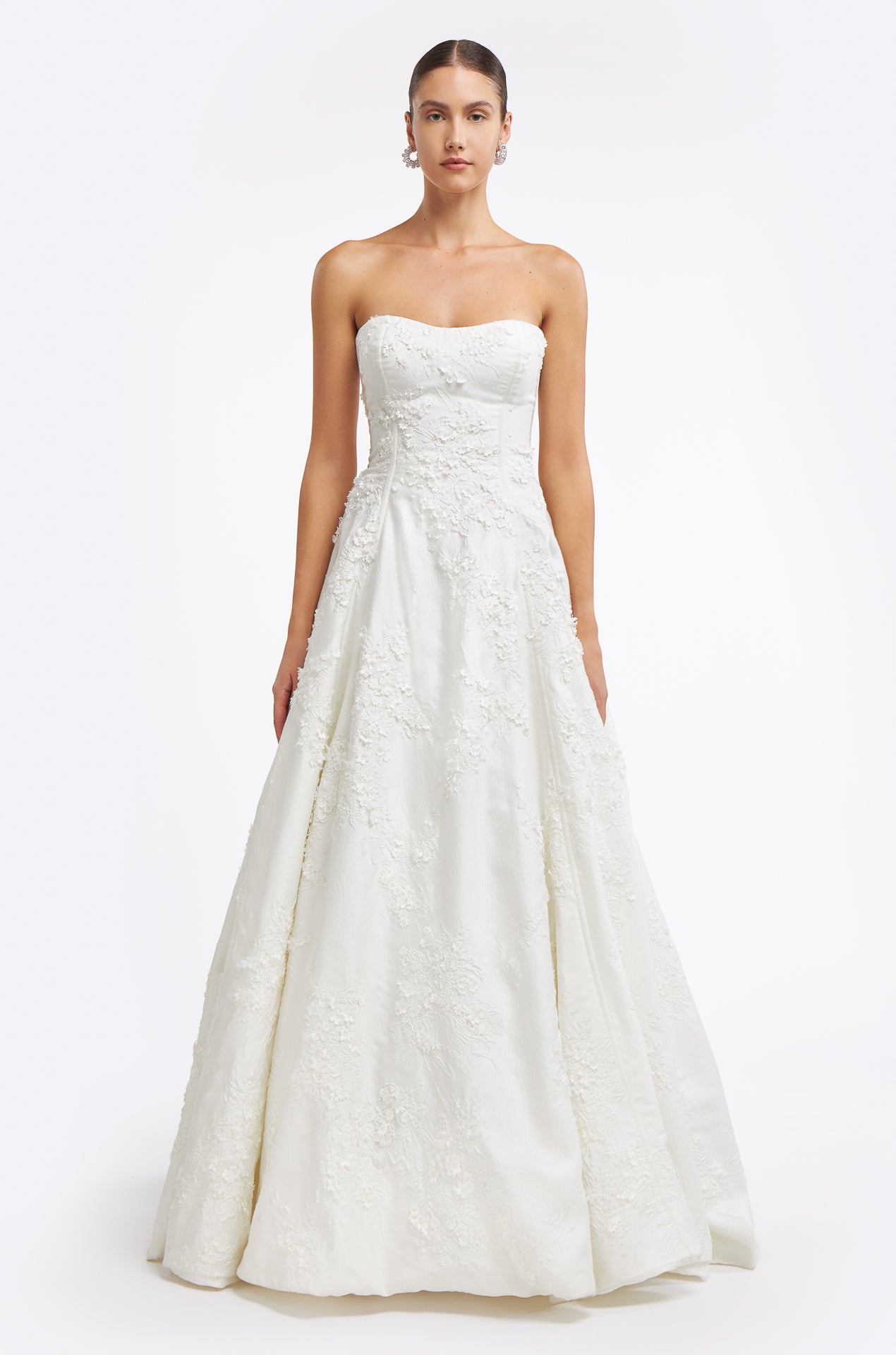 Krinna Jacquard Strapless Gown featuring an elegant A-line silhouette with intricate floral embroidery, perfect for a timeless bridal look.